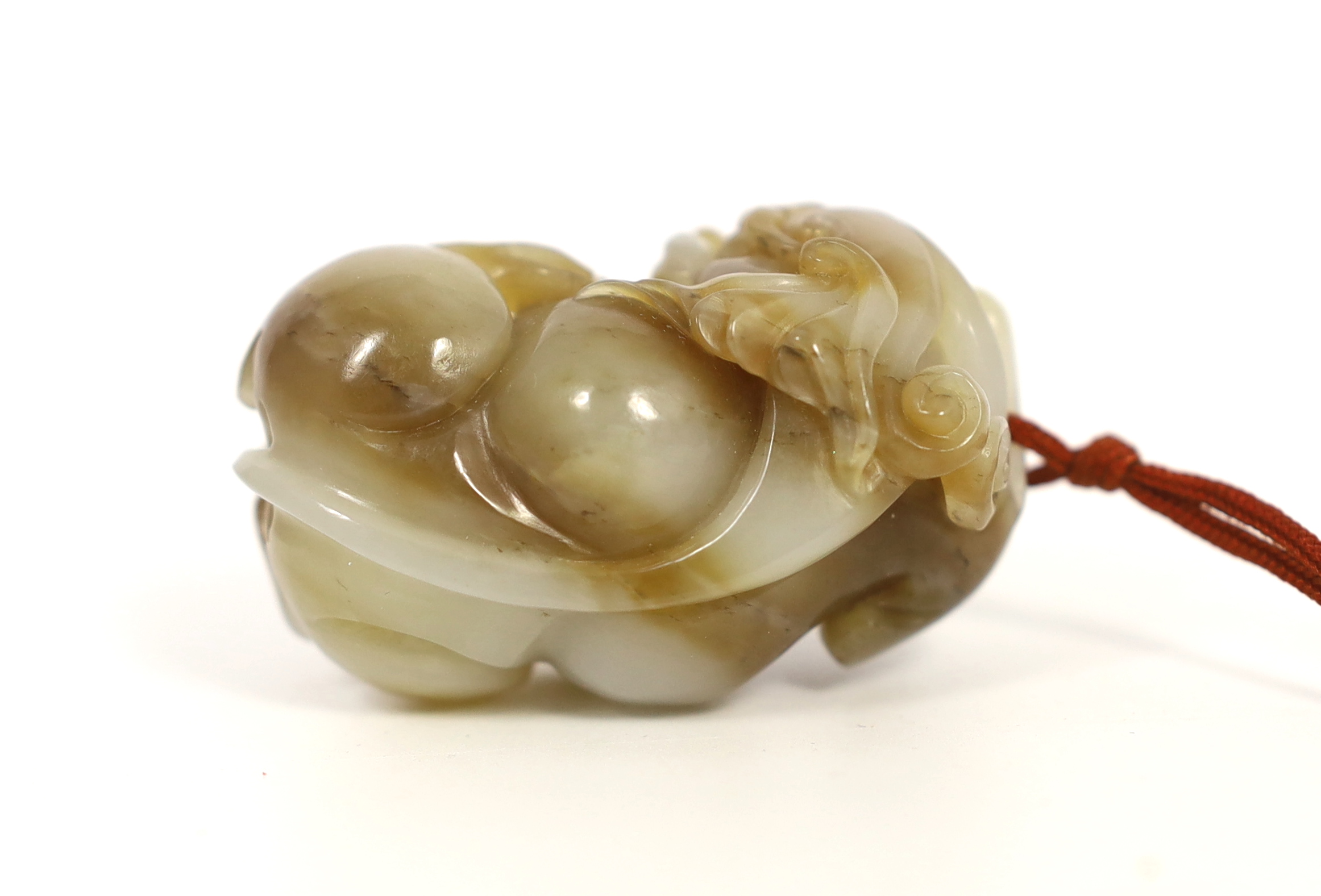 A Chinese white and brown jade lion-dog carving